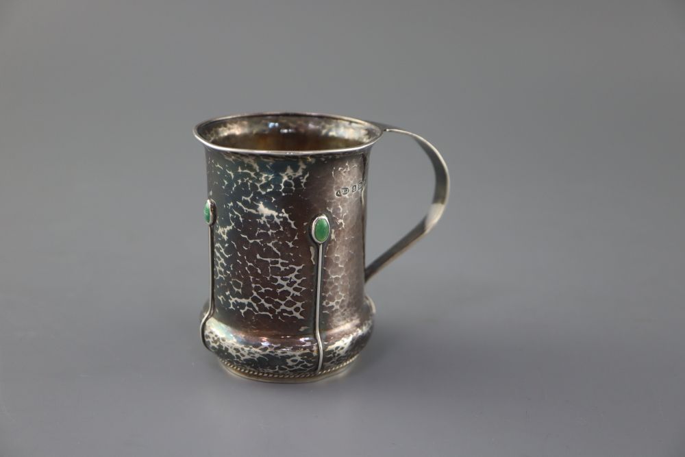 An Edwardian Arts & Crafts silver and turquoise cabochon set mug, by Albert Edward Jones, Birmingham, 1904, 82mm, gross 112 grams.